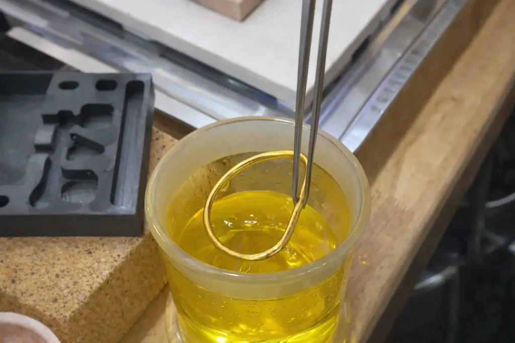A gold bangle being dissolved in aqua regia solution for illicit extraction.