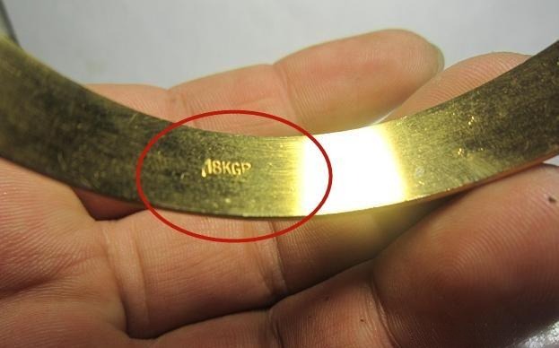 Macro shot of a GP hallmark on a gold-plated bangle.