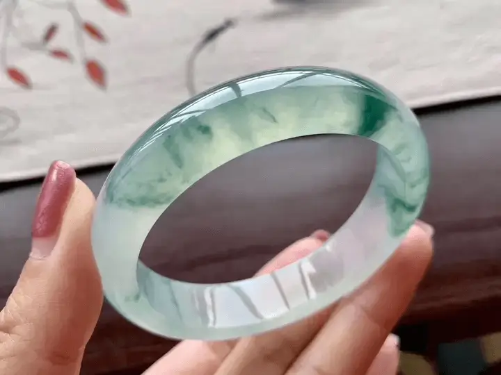 Jewea showcases a custom handcrafted Jadeite bangle with polished translucency and elegant green tones.