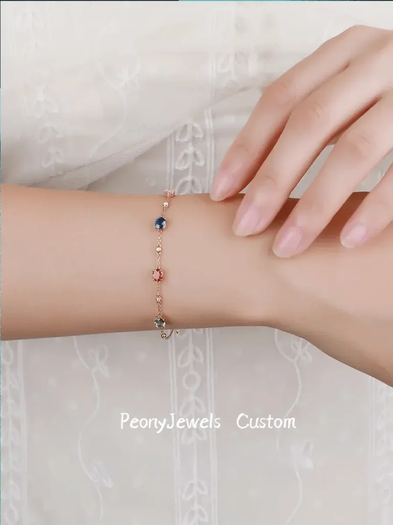 Custom Jewea chain bracelet featuring multi-colored sapphires and diamonds set in yellow gold.