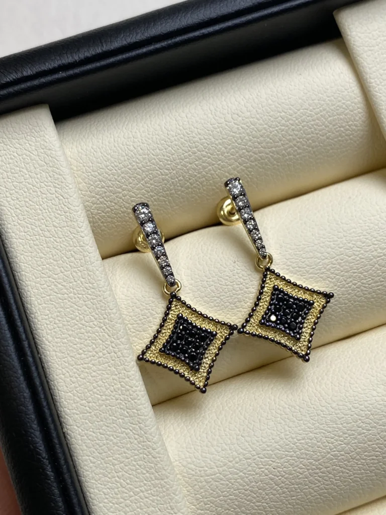 Jewea Zircon stud earrings crafted in 925 silver with electroplated gold and black gold finishes.