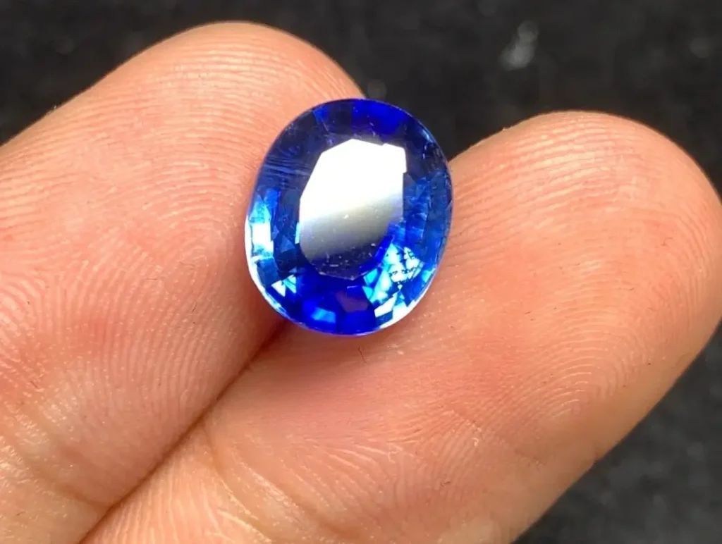 Jewea handheld high-quality faceted gemstone showing subtle natural color banding and deep saturation.