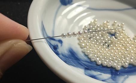 Fifteen carefully selected, perfectly round pearls ready for knotting into a flower ball cluster.