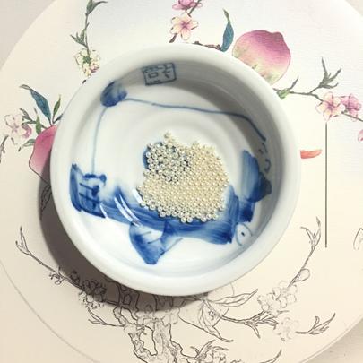 The 15 carefully selected, uniform pearls placed aside, ready for the intricate process of creating the flower ball.