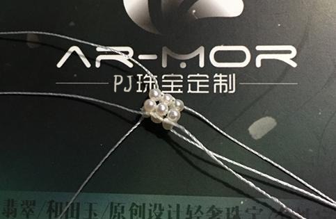 The three pearl rings stacked, with the top layer secured to the middle layer. Knots are staggered, but the structure remains unstable.