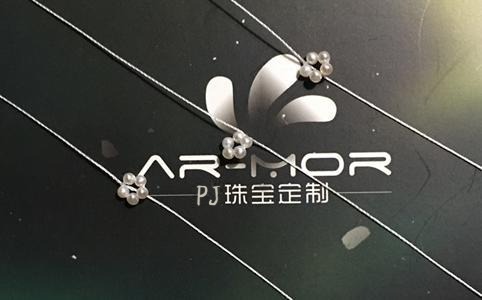 Three completed pearl rings, each made from five pearls knotted together, with long thread tails remaining.