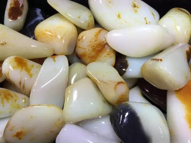 Close-up of high-quality Ziyu (seed jade) stones, showing fine texture and a yellowish-greenish hue due to high tremolite content.