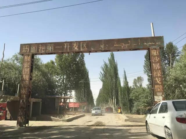 Entrance sign for the Mariyan Bazaar, the remote source market for Xinjiang Hetian Jade, with baskets of rough stones visible.
