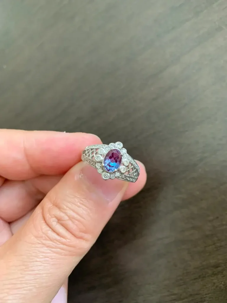 An Alexandrite statement ring with a diamond halo setting, highlighting the central stone's color.