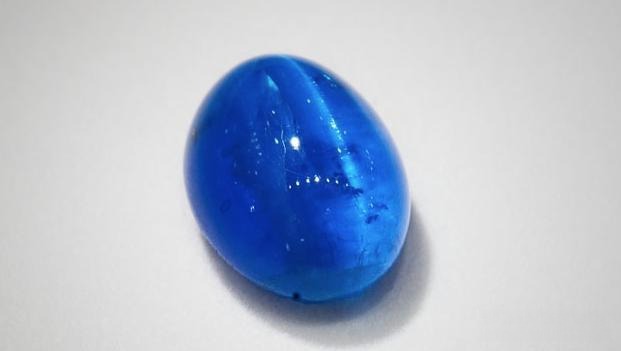 12.50-carat Brazilian blue cat’s eye apatite gemstone displaying strong chatoyancy and vivid blue color.