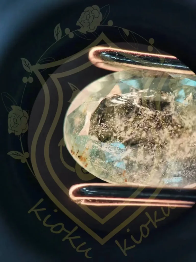 Yellowish-brown mica flakes and mineral crystals trapped inside a faceted Brazilian emerald