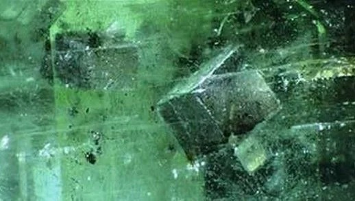 Rhombohedral magnesite crystals as solid inclusions inside a transparent Brazilian emerald.
