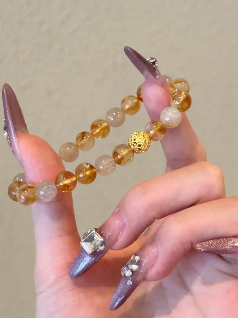 Citrine gemstone beads paired with solid gold bracelet, showcasing natural and treated quartz variations.