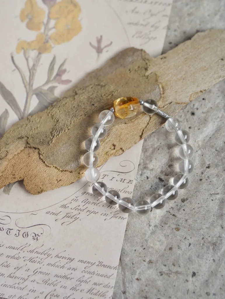 A transparent clear quartz beaded bracelet, displaying high-clarity rock crystal gemstones.