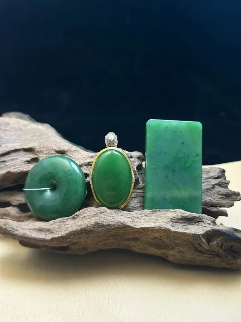 Comparing green nephrite jade pendants from Canada, Russia, and Pakistan on a neutral background.