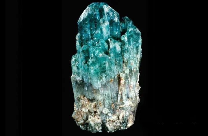 Copper-bearing gemstone crystal showing key gemological properties, including trigonal system, hardness, refractive index, and luster.