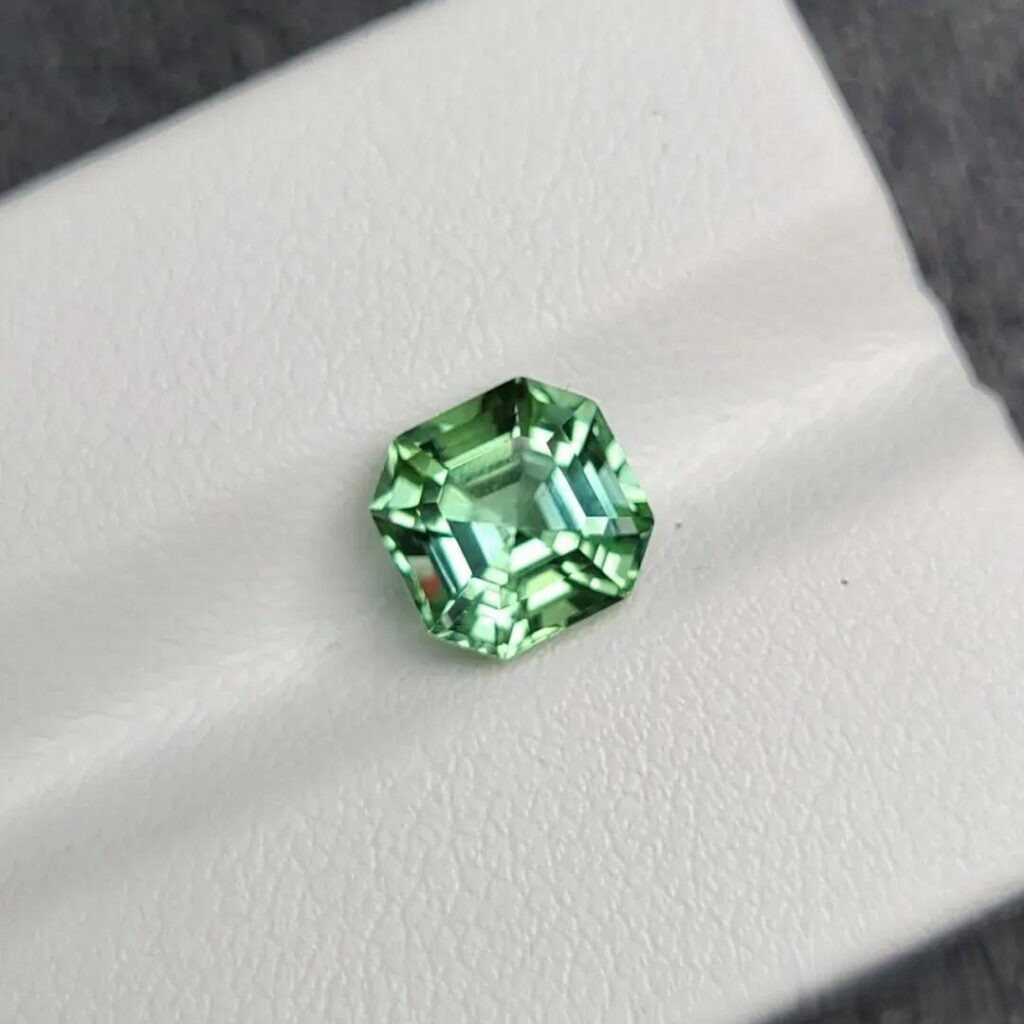 A cushion-cut Lagoon tourmaline displaying a bright electric blue-green hue from Afghanistan.