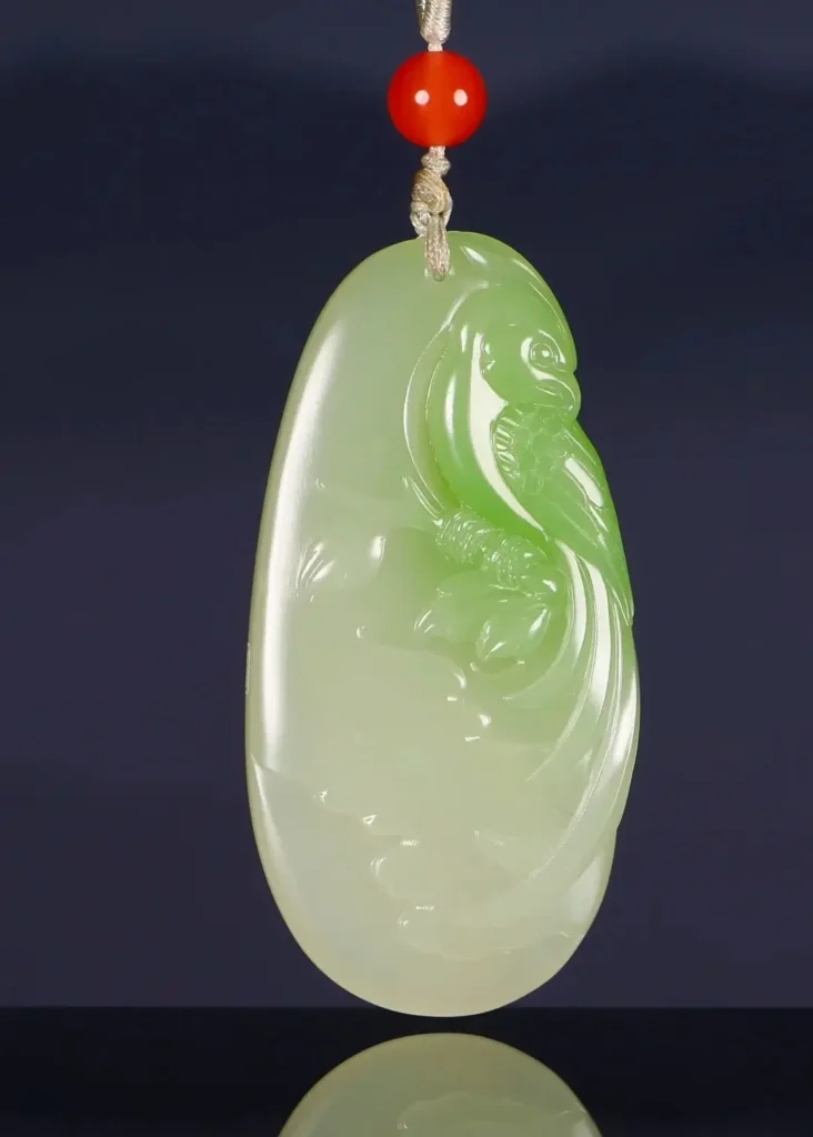 A 37.2-gram Hetian jade pendant featuring a vibrant emerald-green splash on a white nephrite base.