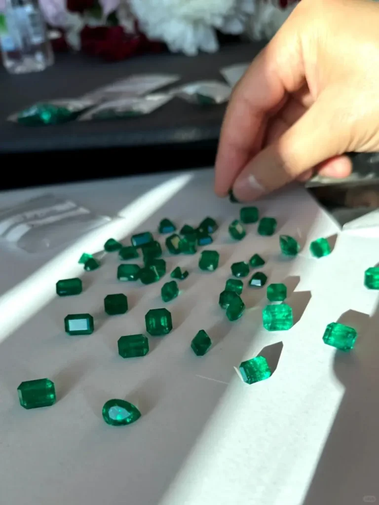Display of various faceted Panjshir emeralds including emerald, oval, and pear-shaped cuts.
