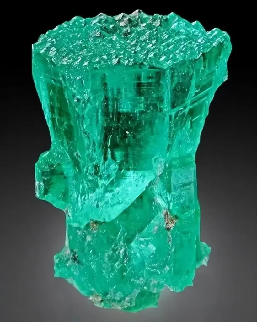Naturally formed hexagonal columnar emerald crystal from Colombia with vivid green saturation.