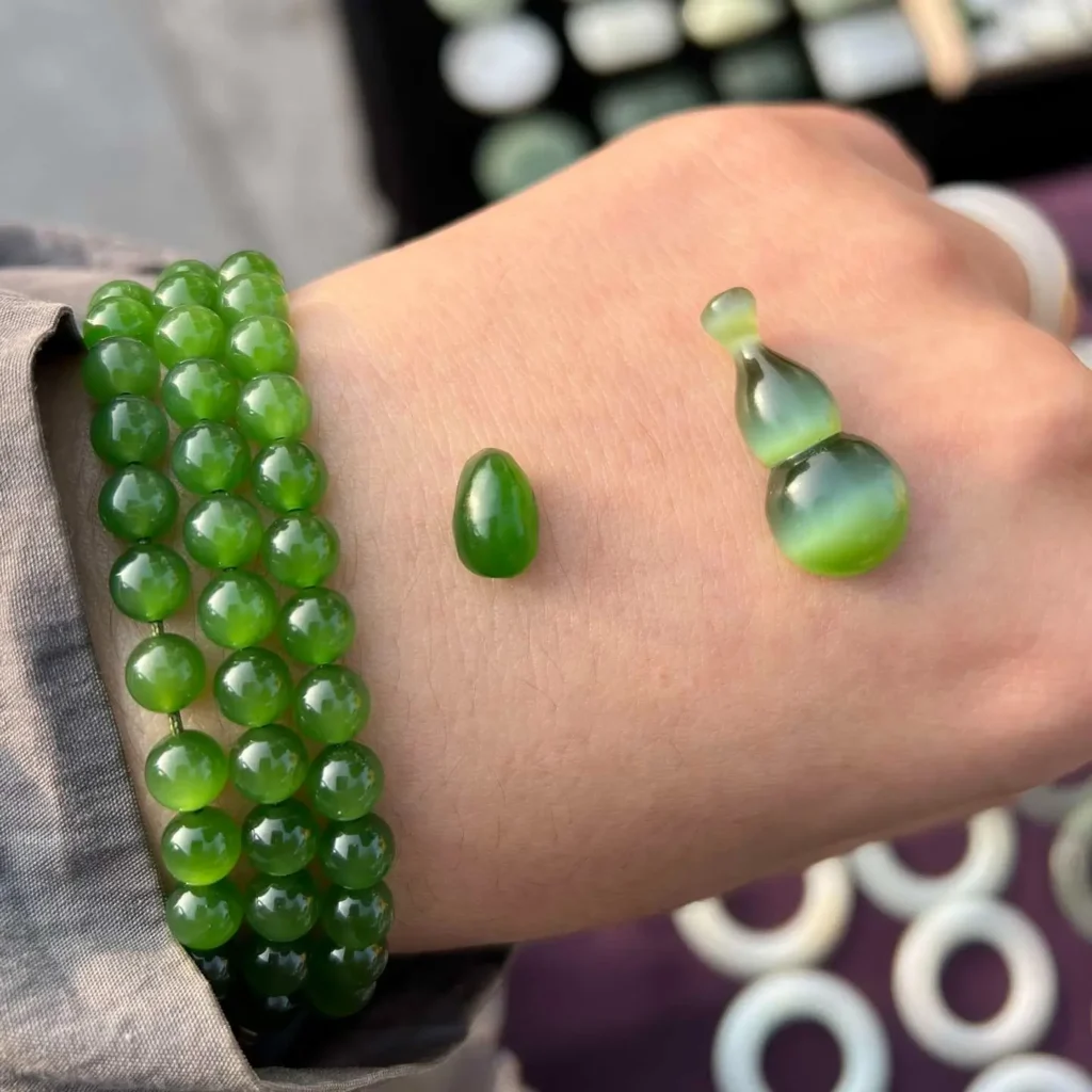 Display of Russian nephrite jade by Jewea, showing vivid green color and polished surfaces.