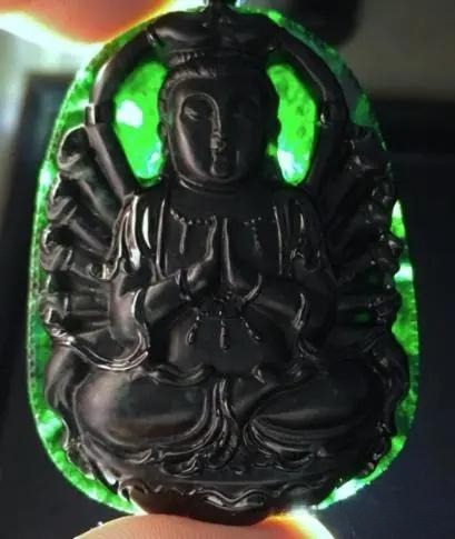 Opaque, dark grayish-black Guanyin pendant carved from kosmochlor-rich jadeite with a matte finish.