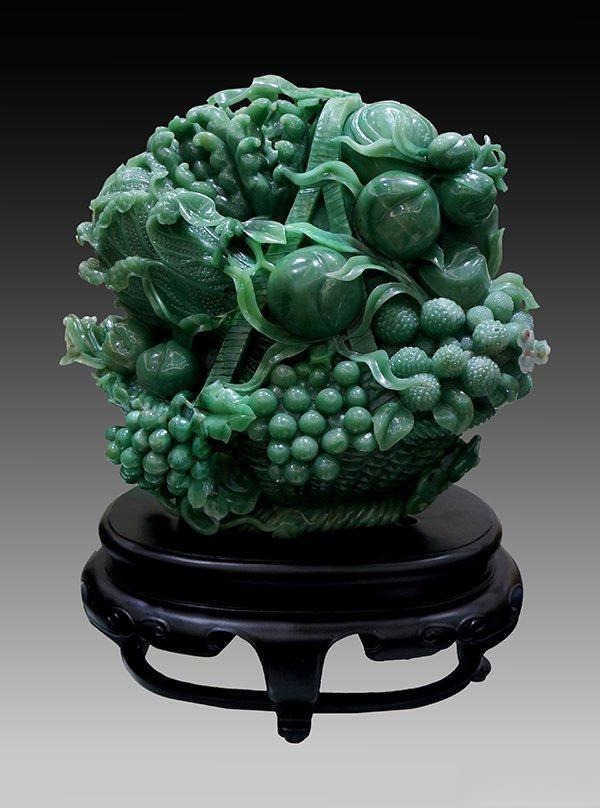 A green Mi Jade fruit carving from Henan, China, showcasing its fine-grained quartzite texture.