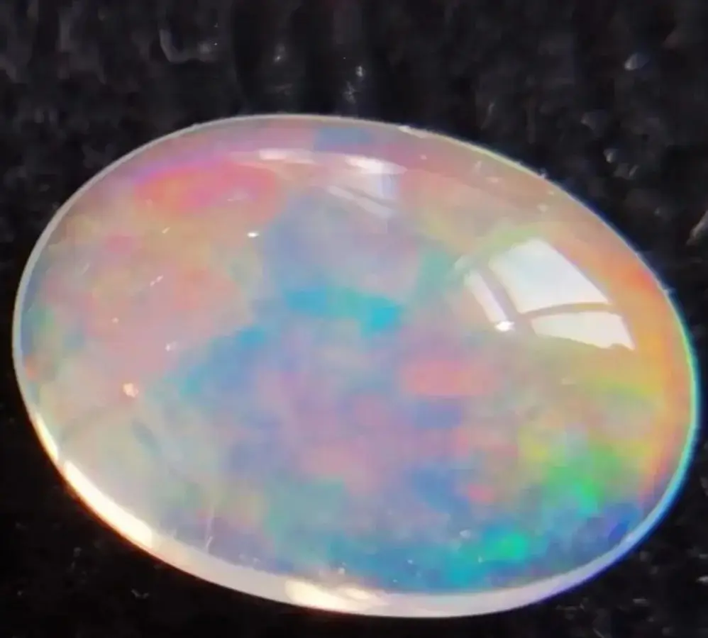 A natural opal specimen representing amorphous silica, lacking the fixed crystal structure of quartz.