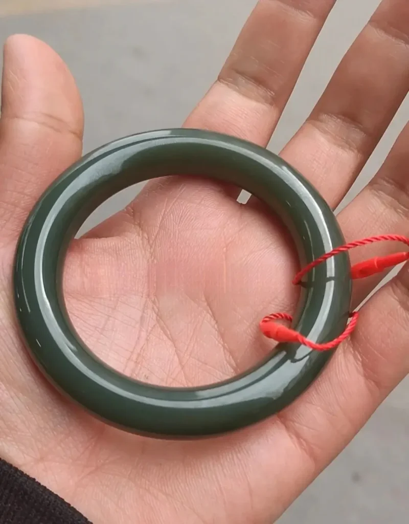 A high-end Afghan nephrite jade bangle with a rich oily luster and deep forest green color.