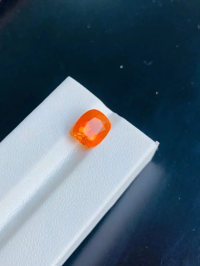 Opal Buying Guide: Transparent deep orange-red fire opal without play-of-color showing vitreous luster.