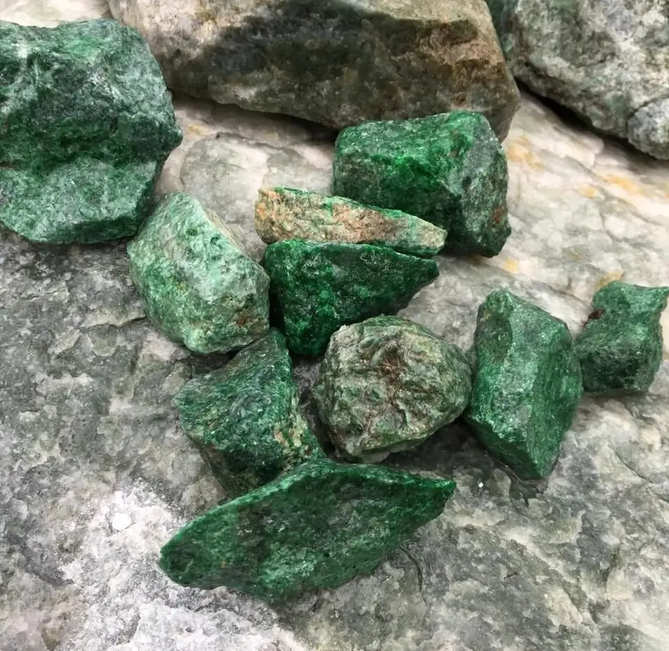 Rough Russian jade boulder with a dark weathered crust revealing a deep forest-green interior.