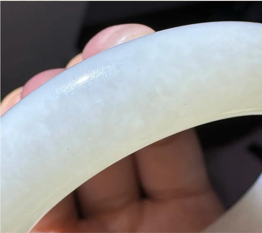 Distinctive rice porridge internal structure of Russian nephrite jade visible under a strong flashlight.
