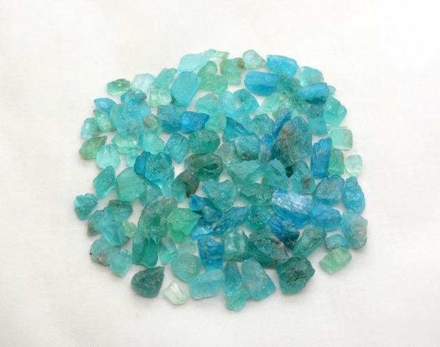 Small rough apatite mineral specimens showing natural crystal shapes and color variations in raw form.