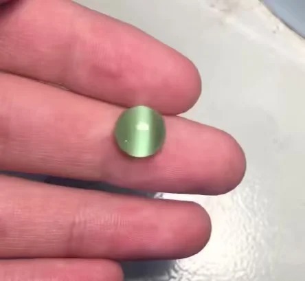 Synthetic glass Cat’s Eye gemstone, illustrating a common imitation of Chrysoberyl Cat’s Eye in the market.
