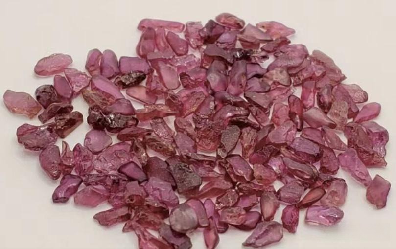 Rough and faceted Thai rubies showing a deep, brownish-red color characteristic of basalt origins.