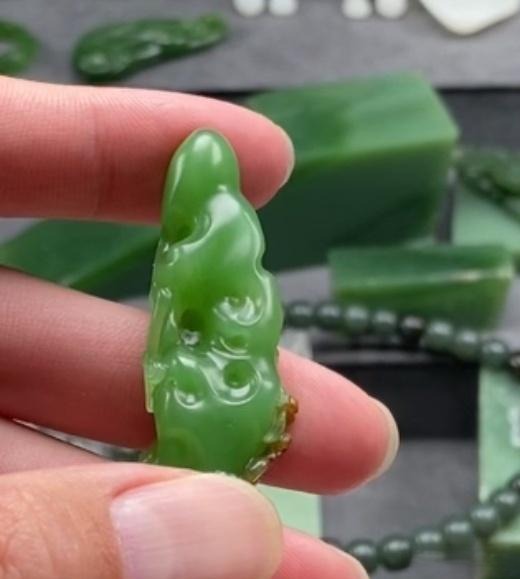 Saturated Ulan-Ude nephrite jade with deep green color and characteristic blocky dark inclusions.