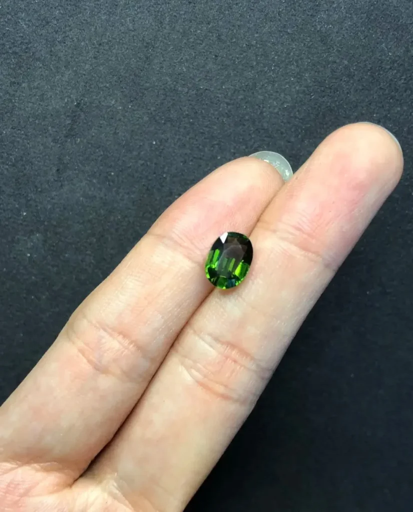 A 1.93ct Tanzanian chrome tourmaline showing green body color and red reaction under Chelsea filter.