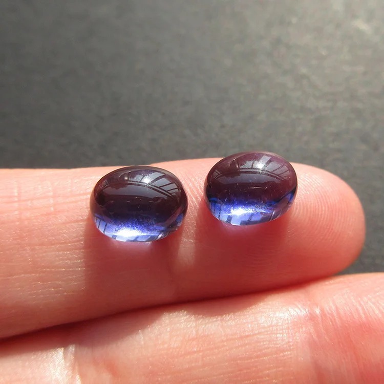 Two 4.8ct eye-clean Iolite gems from Sri Lanka showing violet-blue and straw-yellow pleochroism.