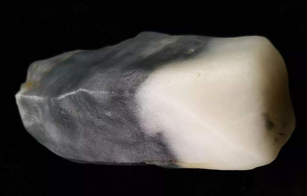 A black and white Jinsi jade raw stone with a granular quartzite structure.