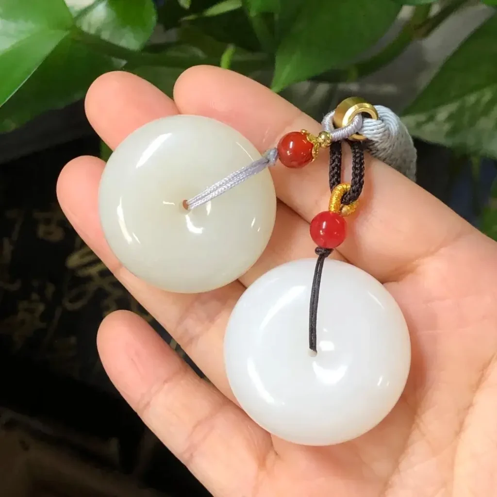 Two jade pendants: left is grayish with loose texture; right is snow-white with dense lipid powder.