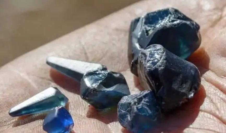 Rough Australian sapphires with a dark inky blue appearance caused by high iron content.