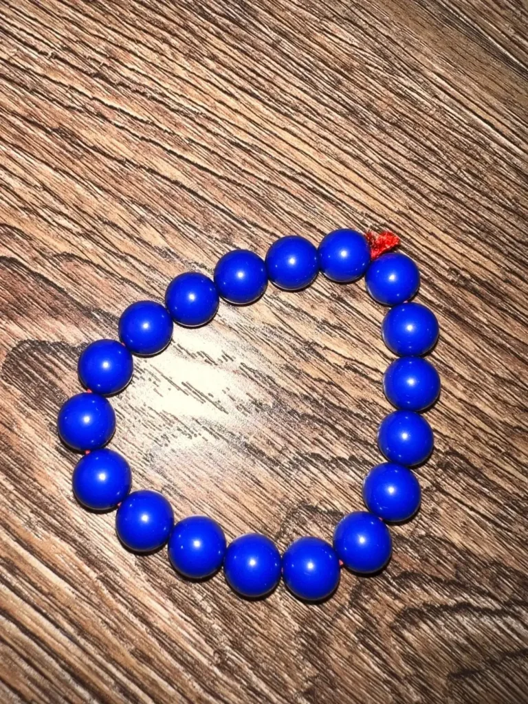 Dyed beads showing unnatural color concentration in surface cracks and pits.