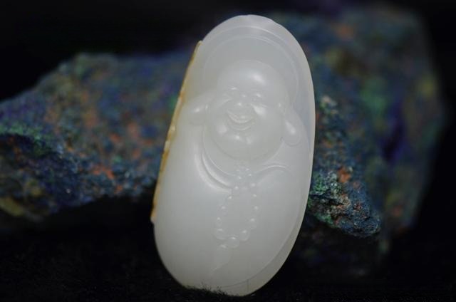 A Buddha pendant made of fine-grained seed jade with a matte, less oily surface appearance.
