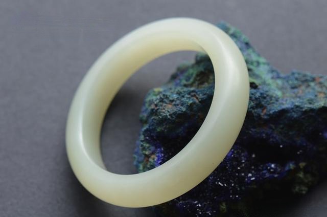 A Grade 2 White seed jade bangle with a grayish base and a fine-grained, structureless texture.