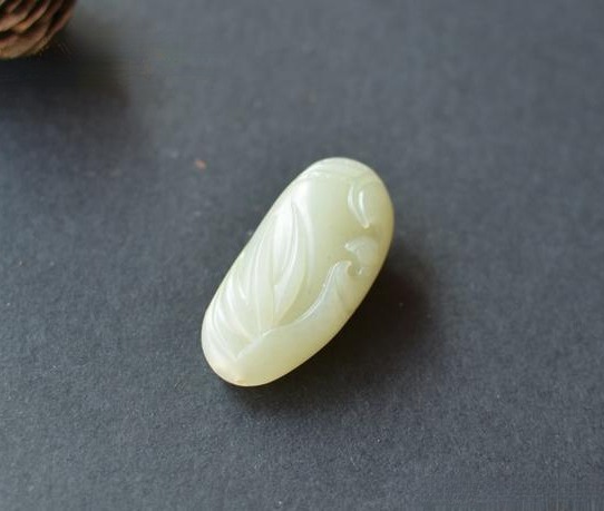 A Grade 1.5 White Hetian Nephrite seed jade carving with a faint greenish-gray undertone.
