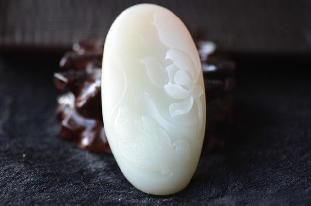 A Grade 1 White Hetian Nephrite carving showing a faint, elegant greenish-white flash.