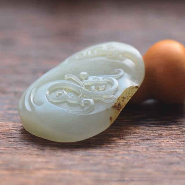 A Grade 2 White Hetian Nephrite dragon pendant with a noticeable greenish-gray base tone.