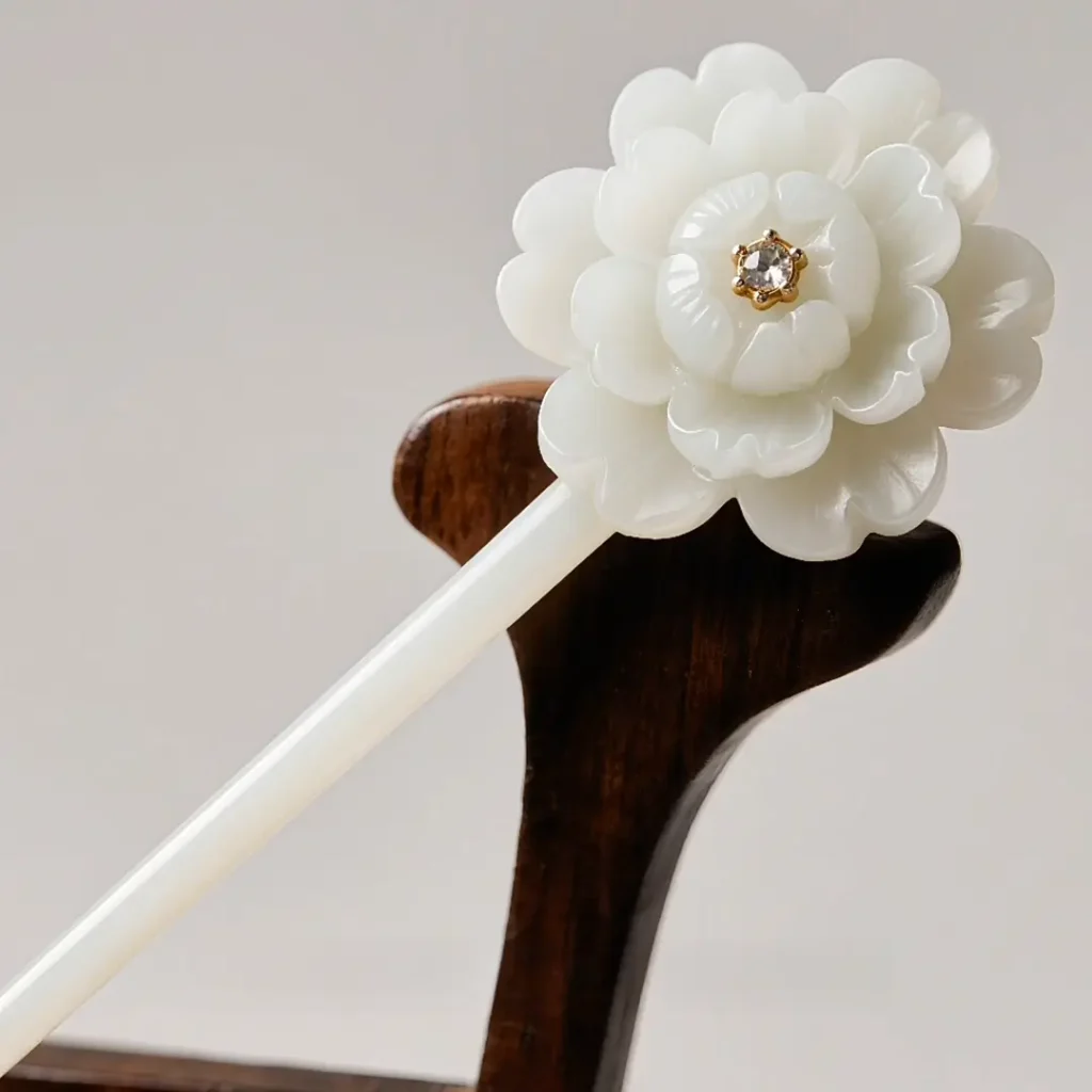 A single-piece white quartz hairpin carved into a lifelike branch with blooming flowers.