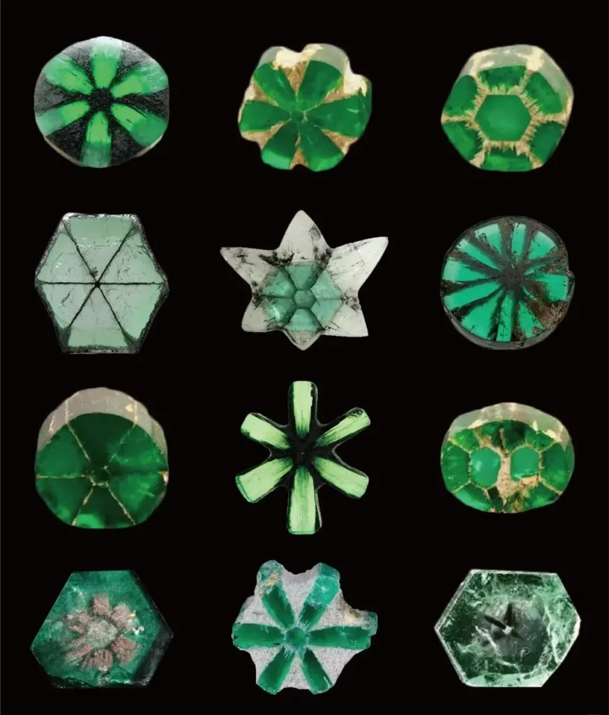 A collection of round, pear, and oval Trapiche Emerald cabochons with six-spoke wheel patterns.