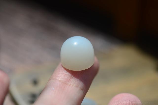 A Mutton Fat seed jade cabochon with a fine-grained texture and a dense, waxy luster.